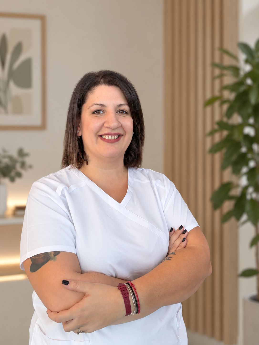 Η Νατάσα Νουρλόγλου χαμογελαστή, με λευκή στολή εργοθεραπείας.